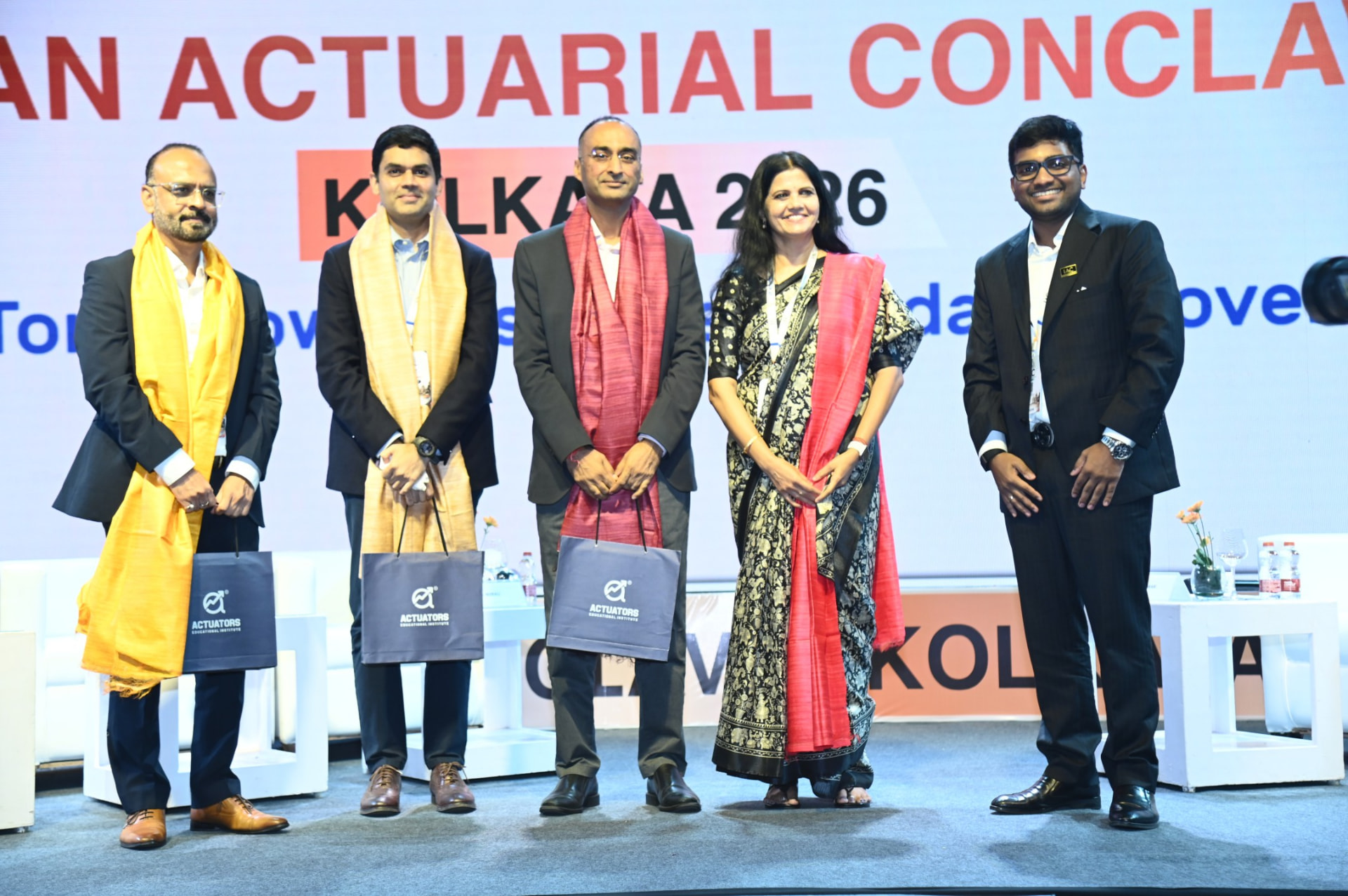 Group photograph of felicitated guests on stage at IAC Kolkata 2026